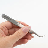 A lash extension tweezer with a comfortable grip and curved tip
