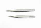 Two pairs of silver tweezers with 'Lashes & Design' branding on a white background